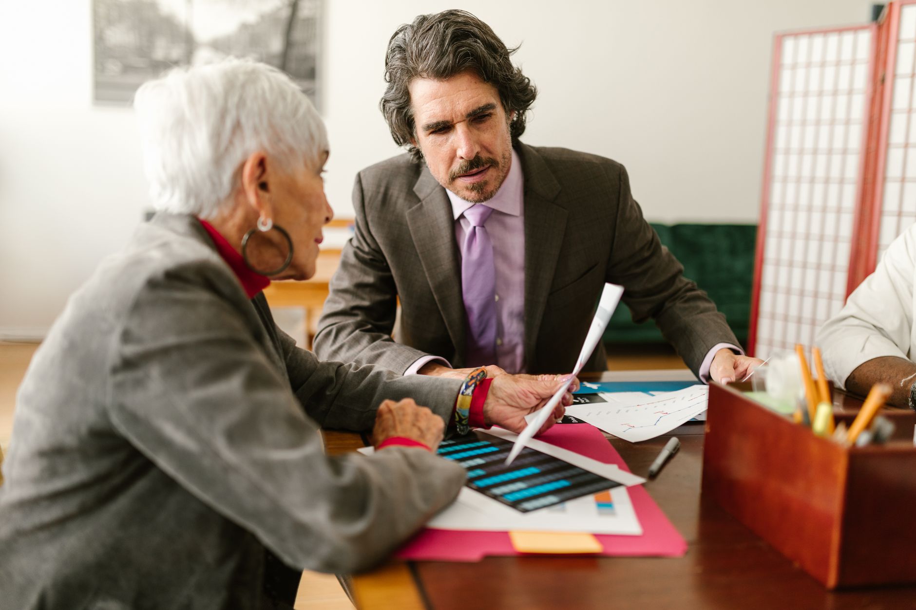A business discussion looking over blueprints and charts